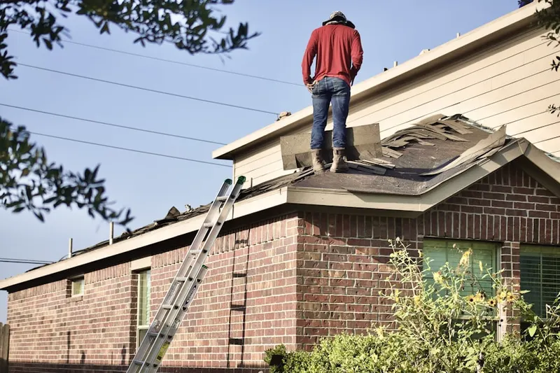 Professional roofer working on a residential roof in Utica